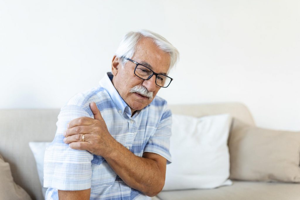 old senior man with shoulder pain upset senior elder man feel sudden back pain muscles ache tension injury home grandfather touching shoulder having osteoarthritis arthritis